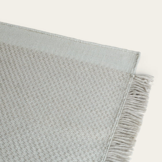 Gray textured blanket with frayed edge on a light gray background #foggray