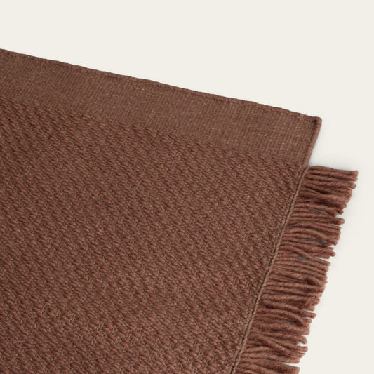 Brown woven blanket with frayed edge on a light beige background #sunsettan