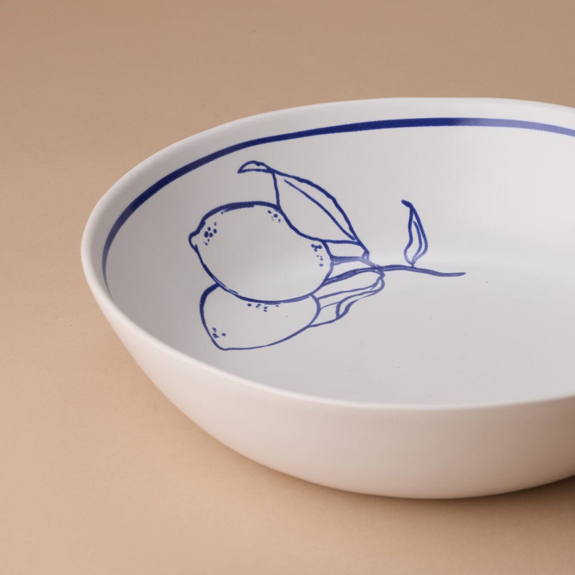 White bowl with blue decorative elements on a beige background