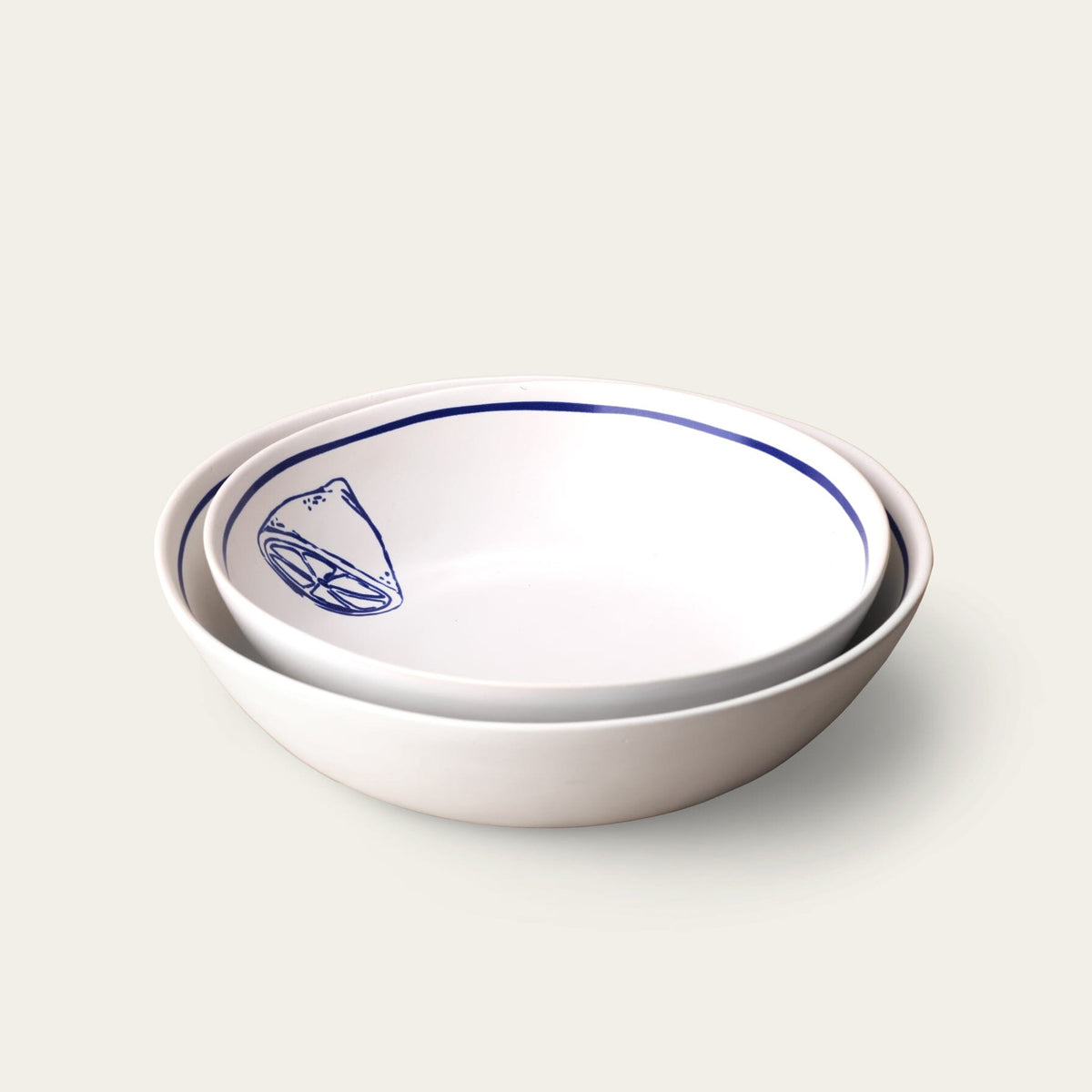 Two white bowls with blue rim and design on a light gray background