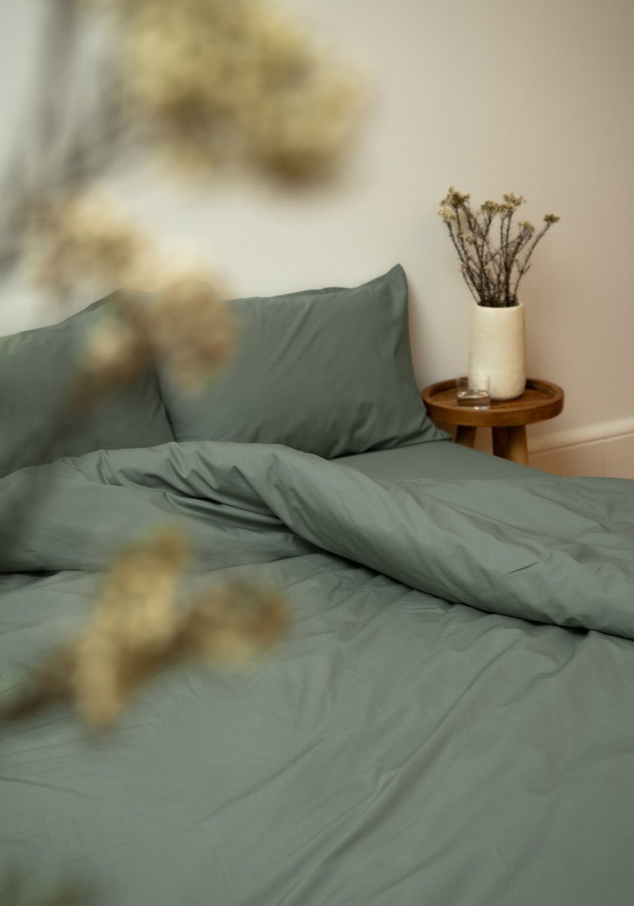 Bed made up in green percale bedding