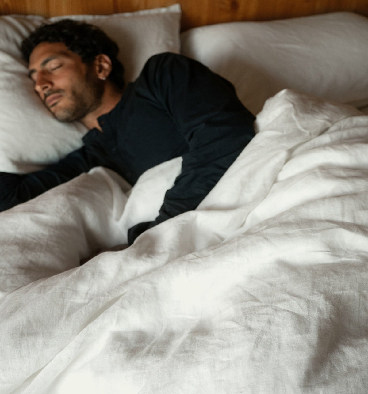 Man asleep under linen bedding